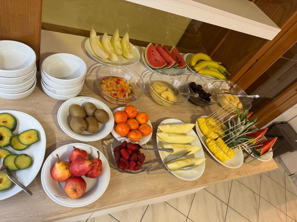 a table topped with plates of fruit and vegetables at Hotel Villa Augusta in Grado