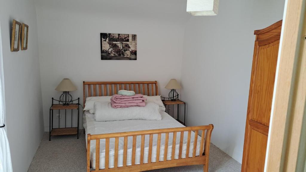 a small bedroom with a bed and two lamps at Les Bigoussies in Ribérac