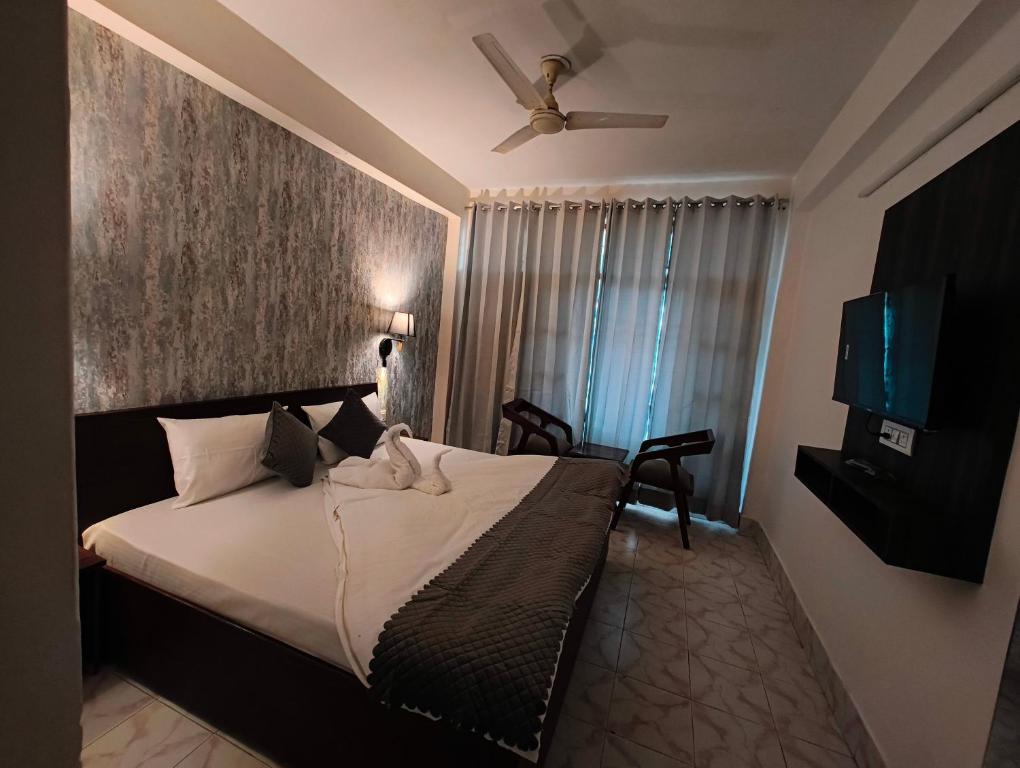 a bedroom with a bed and a flat screen tv at Vibes by Vicctoria House in McLeod Ganj