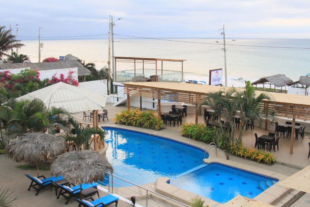 a resort with a swimming pool and tables and chairs at Villa Kite in Santa Marianita