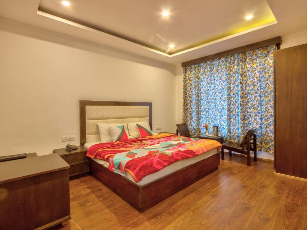 a bedroom with a large bed and a large window at Hotel Karma in Amritsar