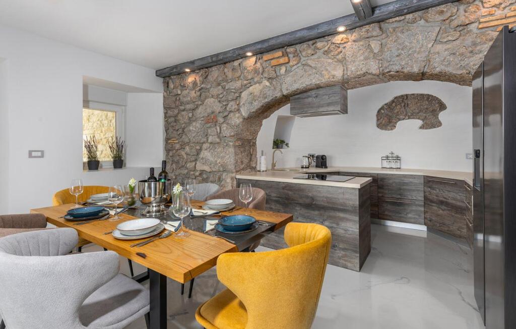 a kitchen and dining room with a wooden table and chairs at Apartman 2A in Breza