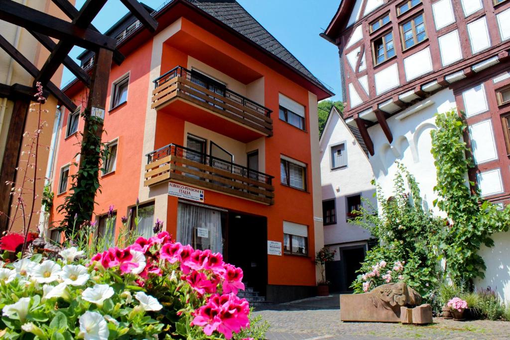 an orange building with flowers in front of it at Pensione Italia in Alf