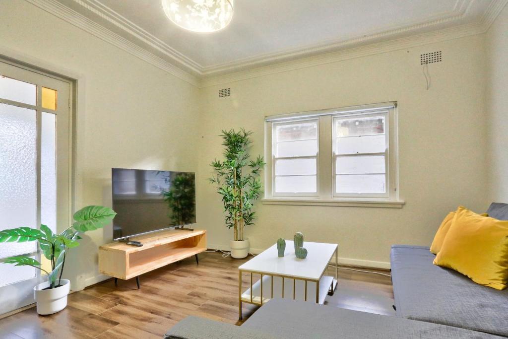 a living room with a couch and a tv at Charming 3 Bedroom on the edge of Downtown Herford St 2 E-Bikes Included in Sydney