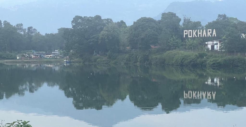 a river with a sign that reads fijikaarma on the side at Hotel Lumbini Resort in Pokhara