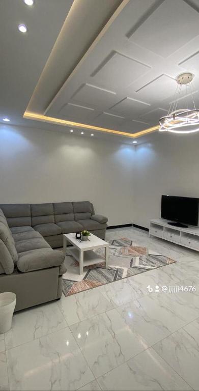 a living room with a couch and a tv at جناح فندقي فاخر in Khamis Mushayt