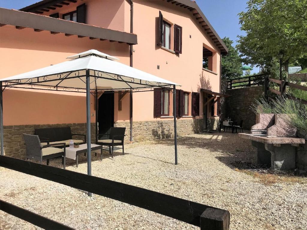 a patio with an umbrella in front of a house at Ferienwohnung für 6 Personen ca 110 qm in Apecchio, Marken Provinz Pesaro-Urbino in Apecchio