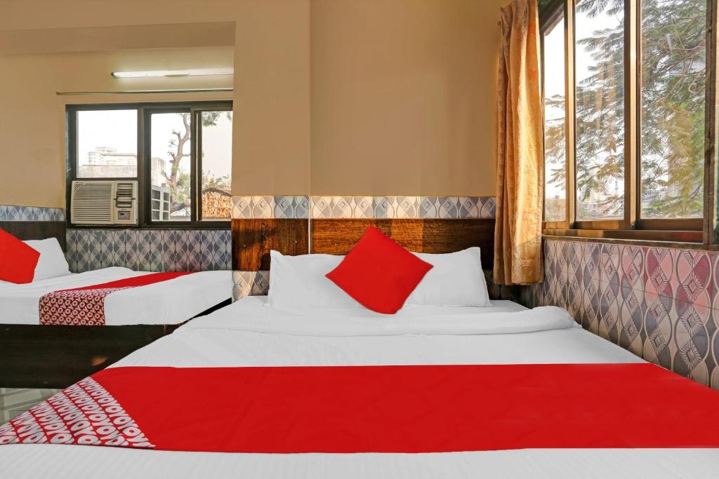 two beds with red pillows in a room at OYO Flagship Hotel Pakeeza in Mumbai