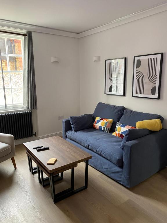 a living room with a blue couch and a coffee table at Beautiful 58 sqm Apartment Zone 2 in London