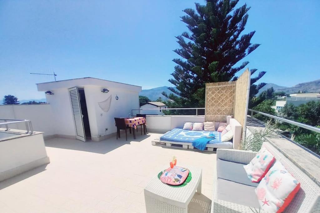 a patio with a couch and a table at Villa Mondello Terraces & Jacuzzi in Mondello