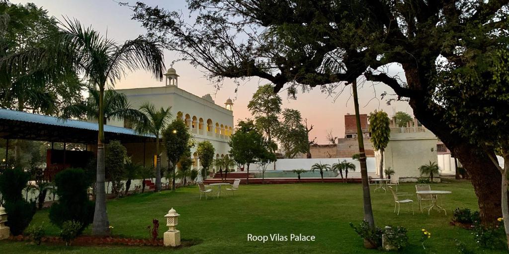 een gebouw met een tuin met stoelen en een brandkraan bij Roop Vilas Palace in Nawalgarh