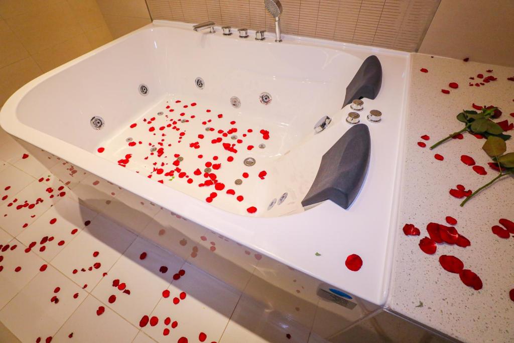 Cheerful Al Waha Hotel Unayzah - فندق شيرفل عنيزة في عنيزة: حوض استحمام مليء بالورود الحمراء على الأرض
