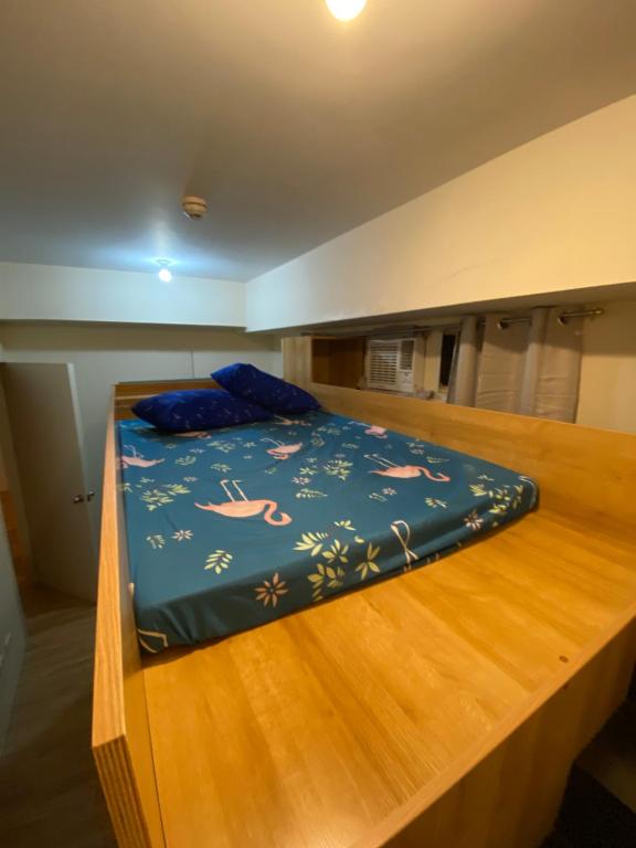 łóżko z niebieską kołdrą na górze w obiekcie Holland Park Condominium w mieście Jalang