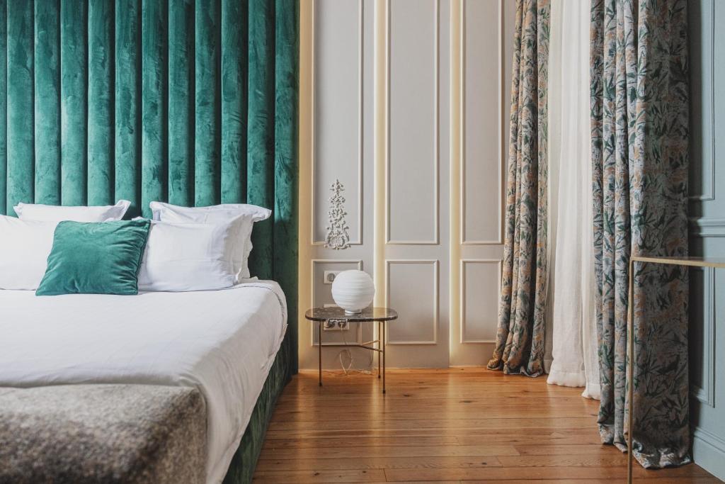 a bedroom with a bed with a green wall at Hôtel Singulier Bordeaux - Boutique Hôtel & Spa Anne Semonin in Bordeaux