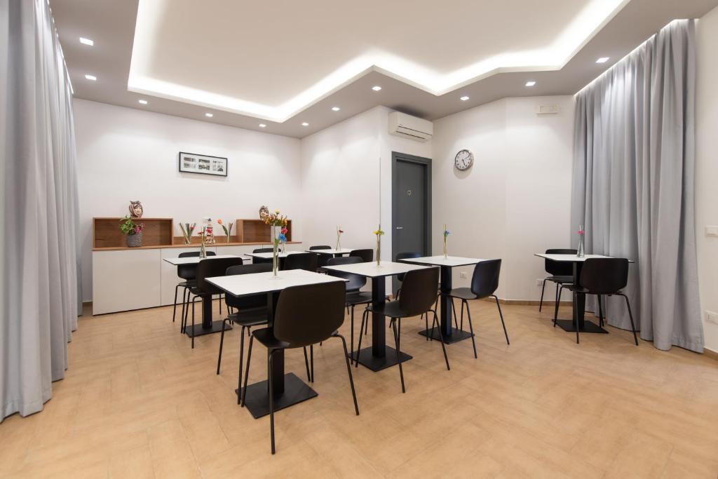 a dining room with tables and chairs and a kitchen at Room & Breakfast Aloe in San Vito lo Capo