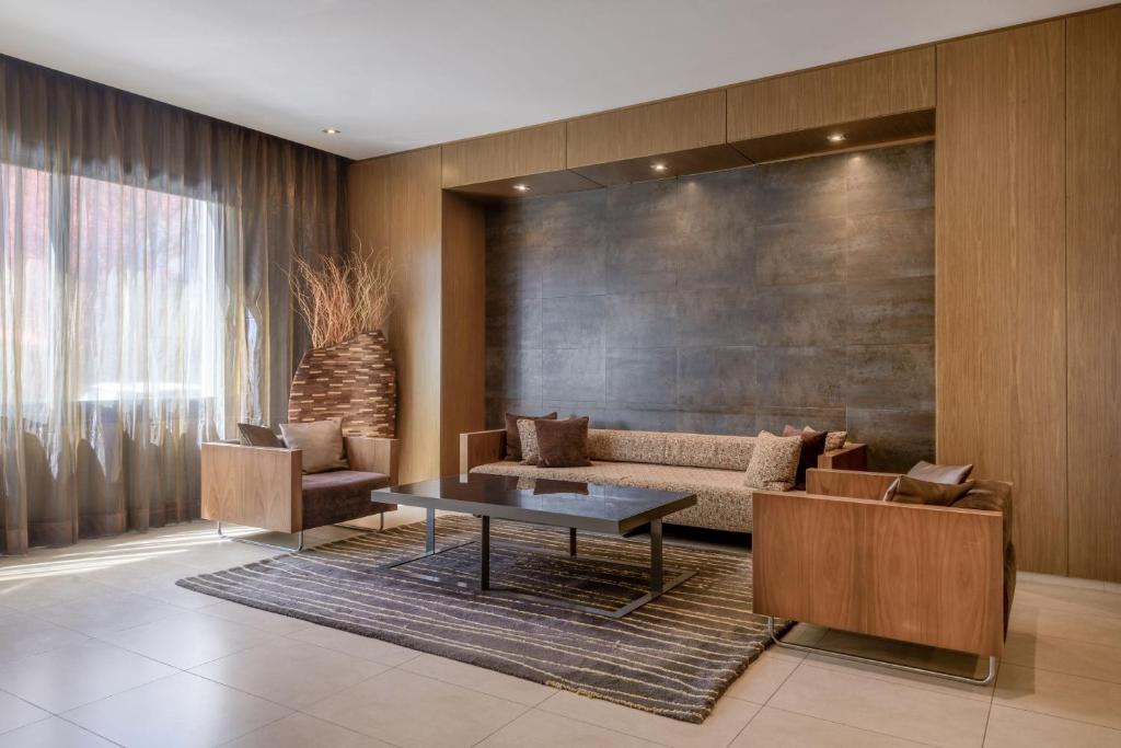 uma sala de estar com um sofá e uma mesa em AC Hotel Vicenza by Marriott em Vicenza