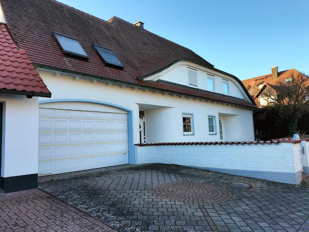een wit huis met een garage en een oprit bij Großzügig-Wohnen nahe Erlangen - Nürnberg in Dormitz