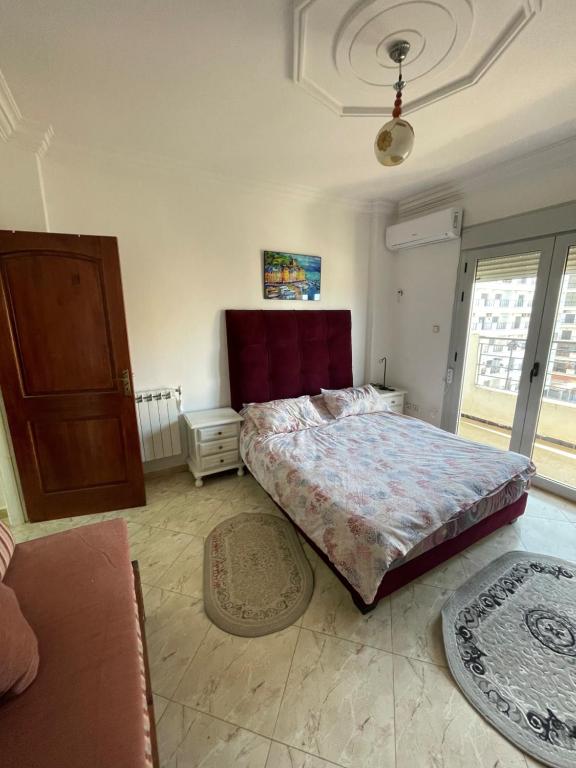 - une chambre avec un lit et un canapé dans l'établissement bel appart mosta, à Mostaganem