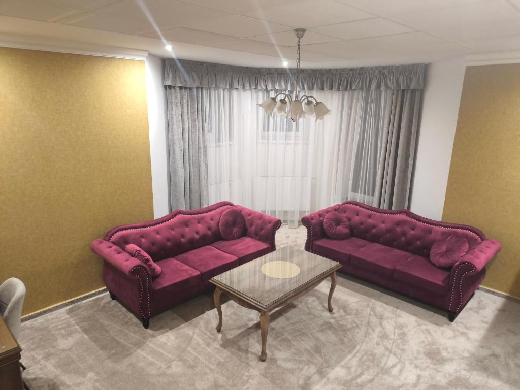 una sala de estar con 2 sofás morados y una mesa. en ApartmanyHurbanova1, en Bardejov