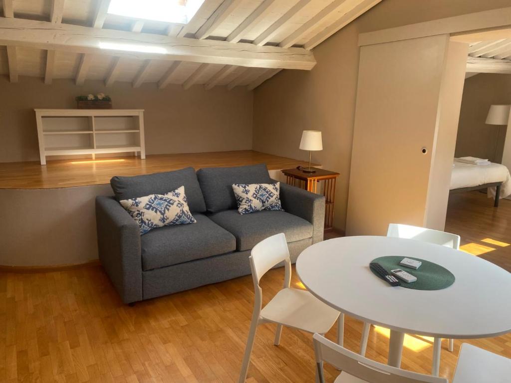 ein Wohnzimmer mit einem Sofa und einem Tisch in der Unterkunft Mansarda Salviatino in Florenz