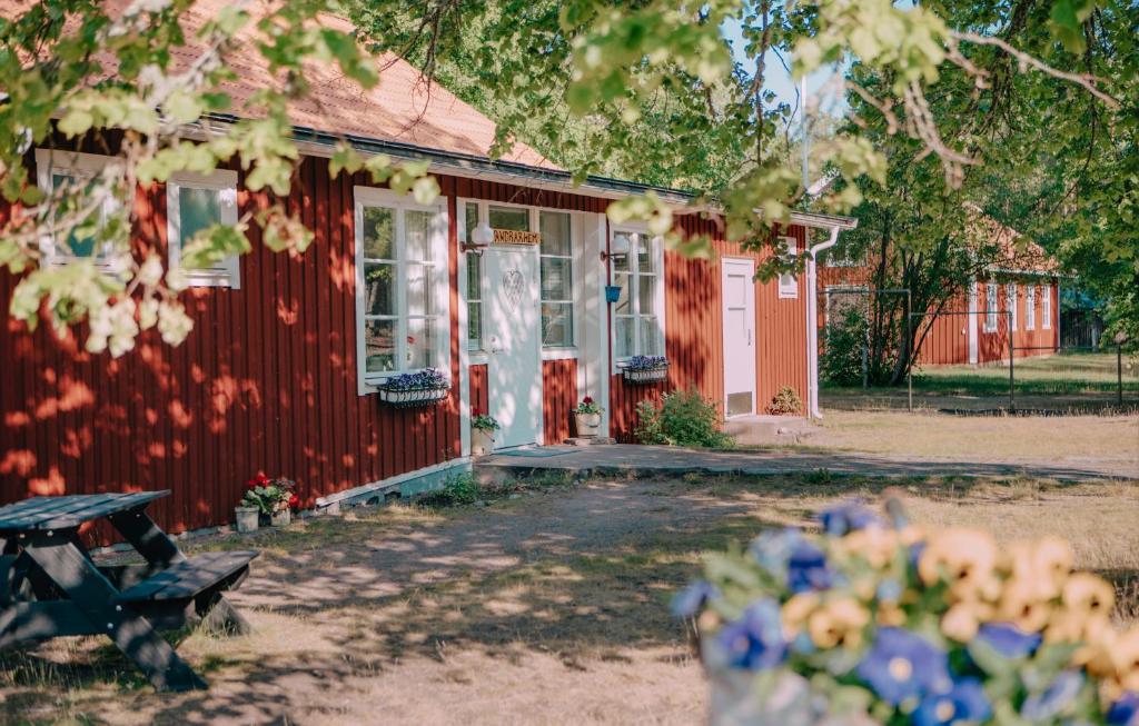 een rood gebouw met een bank ervoor bij Hasselö Hostel in Hasselö