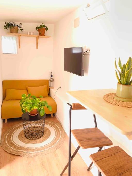 sala de estar con sofá amarillo y mesa en Casita privada, en Alpedrete