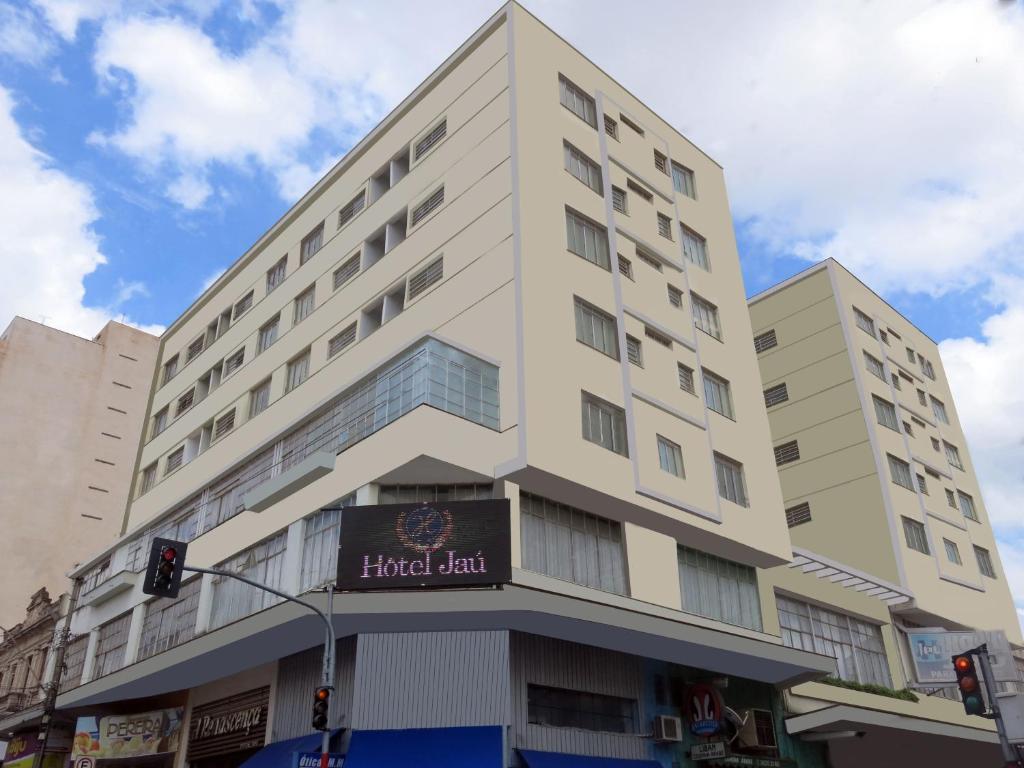 a tall white building with a sign on it at Hotel Jaú by Easy Hotéis in Jaú