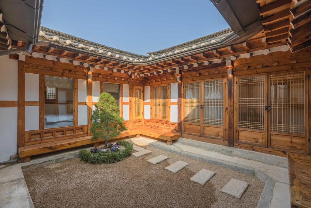 a house with wooden walls and a courtyard at Luxury hanok with private bathtub - Yoojundang in Seoul