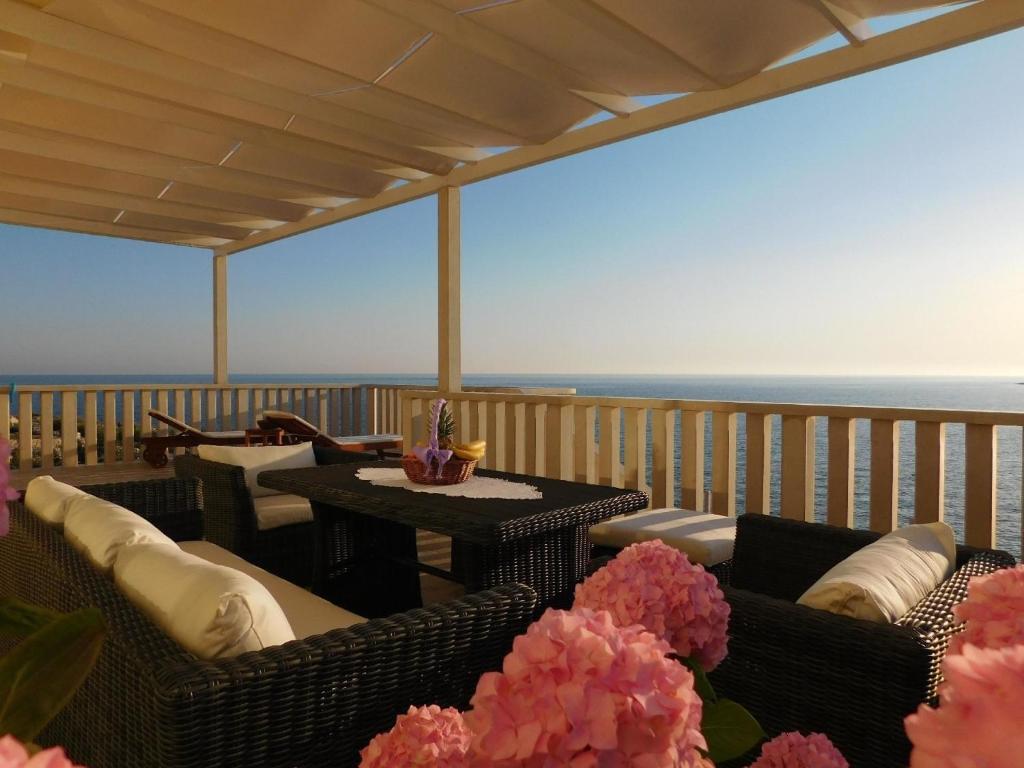 un balcón con 2 sofás y una mesa con flores en Ferienhaus mit Privatpool für 8 Personen ca 150 qm in Sevid, Dalmatien Mitteldalmatien, en Sevid