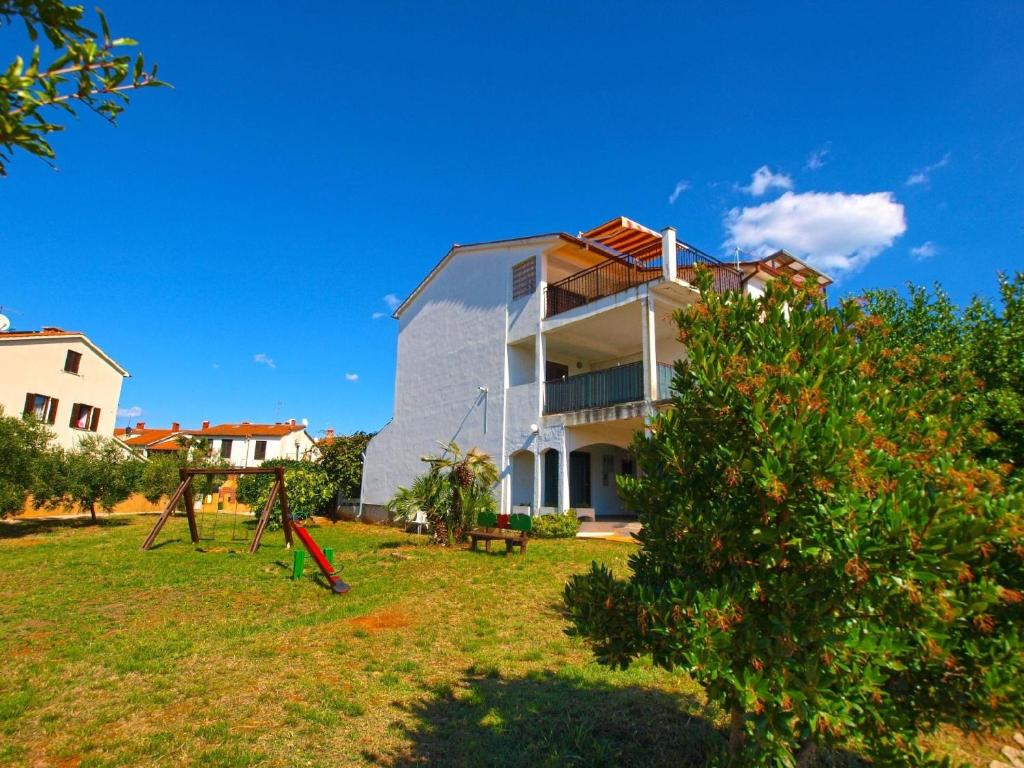 uma casa com um quintal com uma árvore em Ferienwohnung für 4 Personen ca 45 qm in Fažana, Istrien Istrische Riviera - b55457 em Fažana