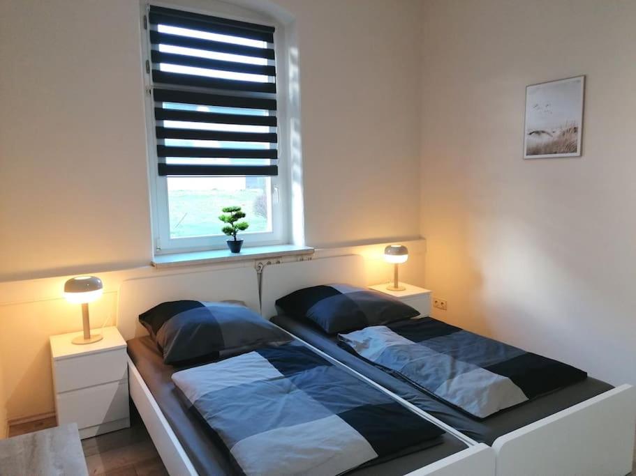 una camera da letto con un letto con due lampade e una finestra di Ferienwohnung und Zimmervermietung Zur Alten Post a Claußnitz