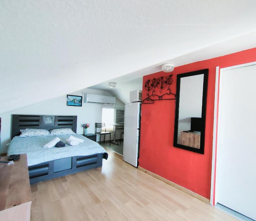 - une chambre avec un lit et un mur rouge dans l'établissement Guest House VeryMary Eilat Stydio, à Eilat