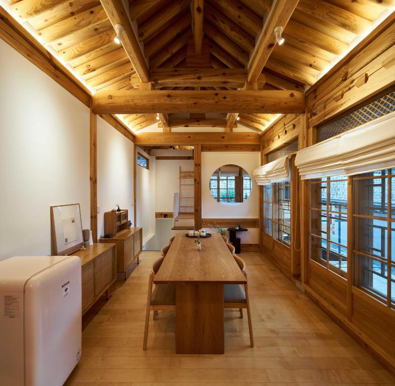 ソウルにあるLuxury hanok with private bathtub - SN01の木製の天井とテーブルが備わる広い客室です。