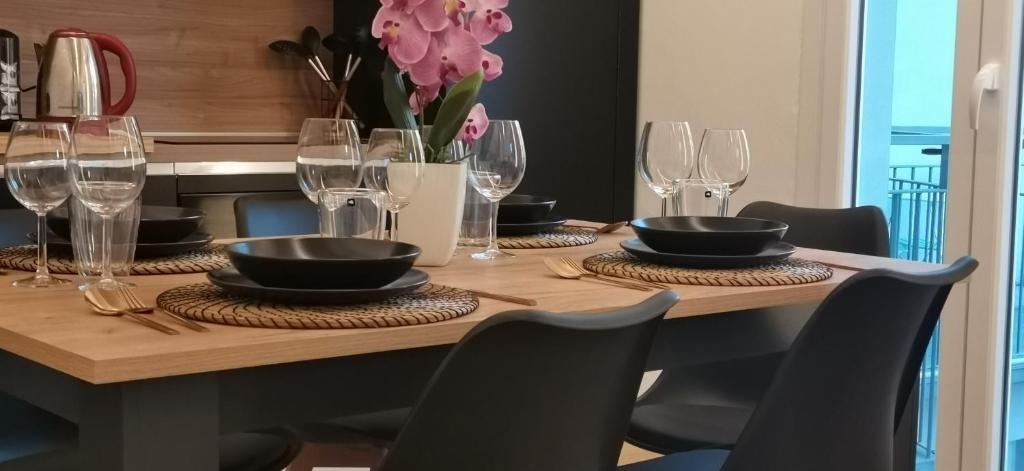 uma mesa de madeira com pratos, copos e flores em Orelli House em Lissone