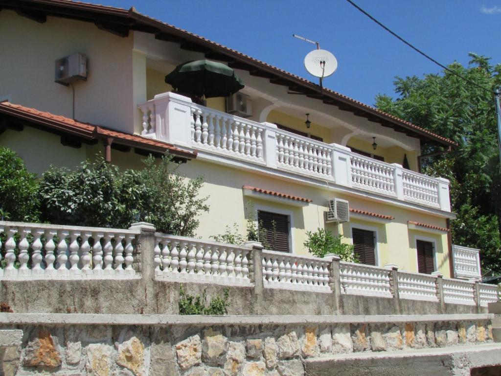 dom z białym balkonem na szczycie ściany w obiekcie Guesthouse Katarina w mieście Opatija