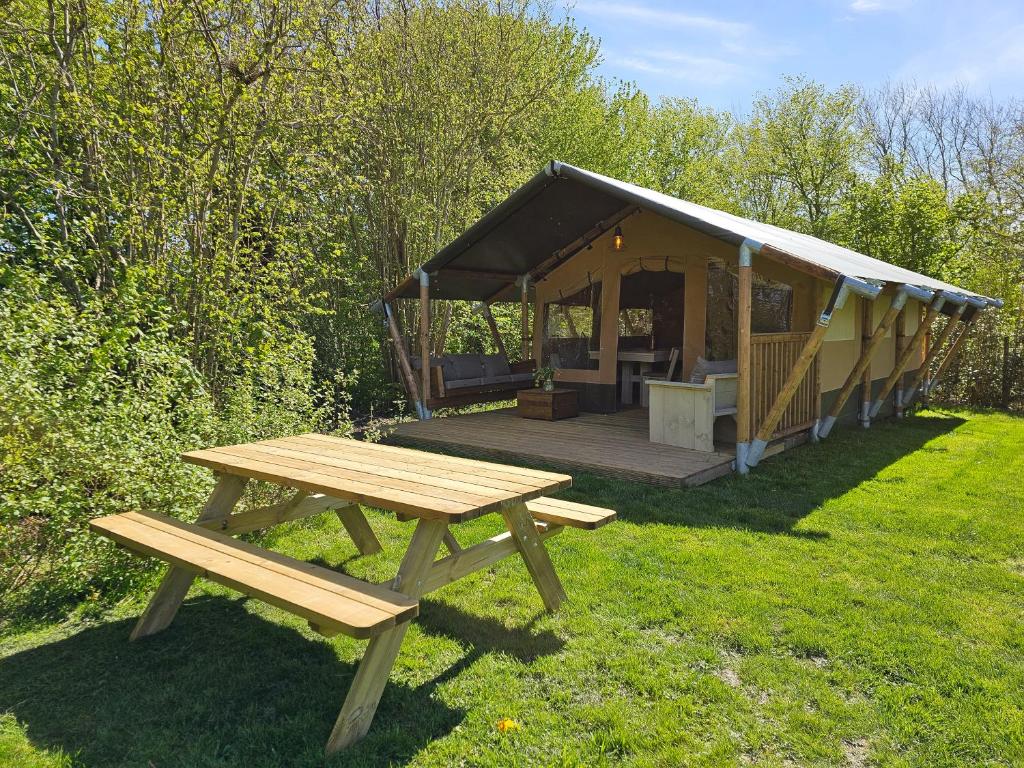 a picnic table in front of a gazebo at Safaritent met privé sanitair in hoofdgebouw in Aagtekerke