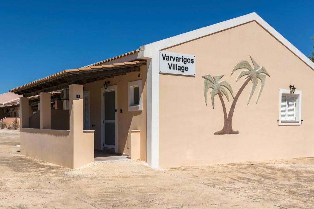 a building with a palm tree on the side of it at Varvarigos Village in Zakynthos Town