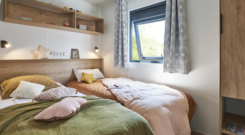 Postel nebo postele na pokoji v ubytování Camping Le Coin Charmant