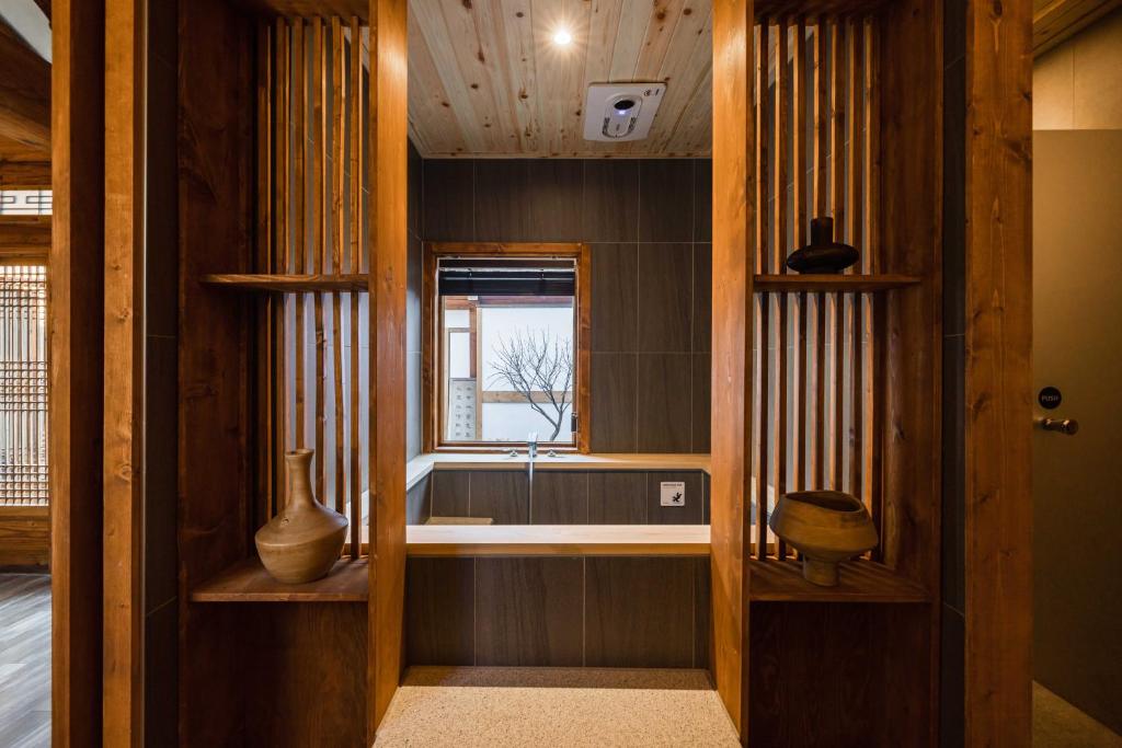 a hallway with a window and a vase on a shelf at Luxury hanok with private bathtub - SN04 in Seoul