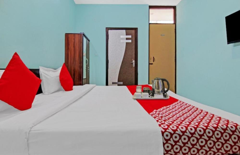 a bedroom with a large white bed with red pillows at Om villa in New Delhi