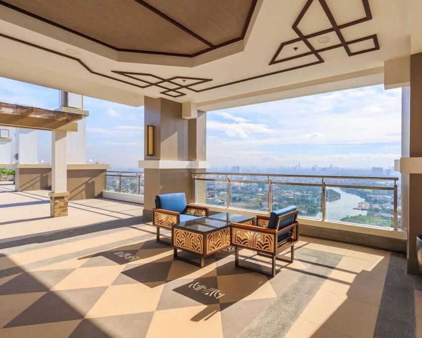 a room with chairs and a balcony with a view at Torre De Manila Stunning Apartment in Manila