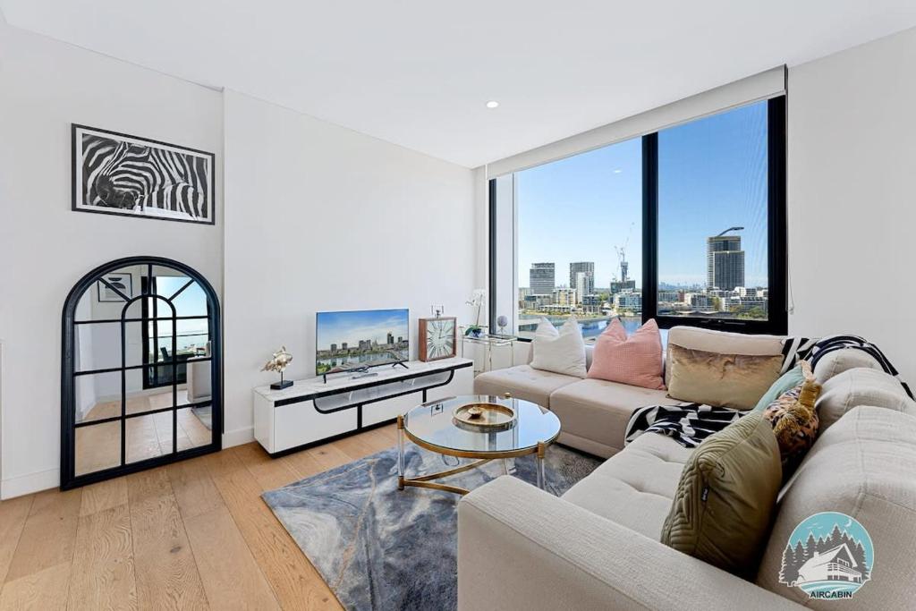 a living room with a couch and a table at Aircabin｜Wentworth Point｜Stylish Comfy｜2 Beds Apt in Sydney