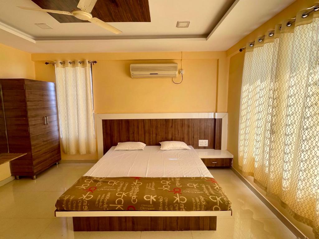 - une chambre avec un grand lit et une fenêtre dans l'établissement Hotel Island, à Kolhapur
