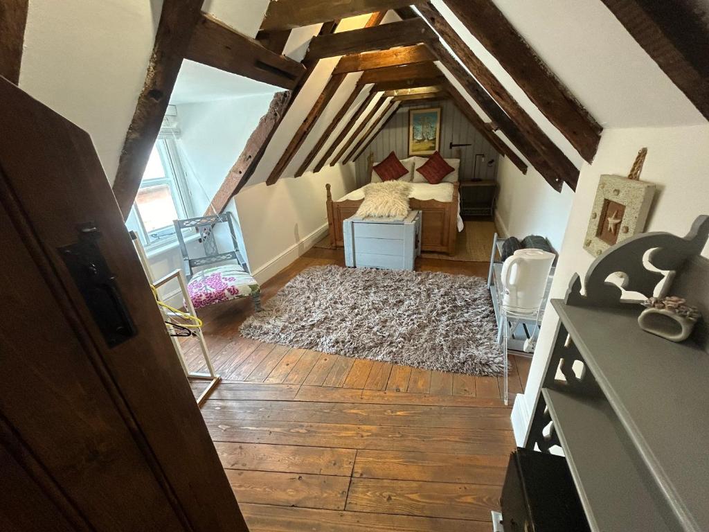 an attic room with a bed and a rug at Cosy, historic cottage, Centre Petworth in Petworth