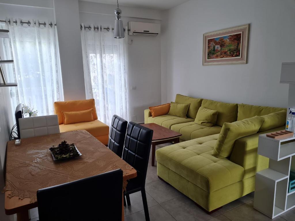 a living room with a green couch and a table at Gjiri I Lalzit apartament in Durrës