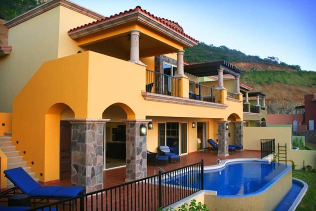 a villa with a swimming pool and a house at Incredible 3BR Ocean View Villa in Cabo San Lucas in Cabo San Lucas