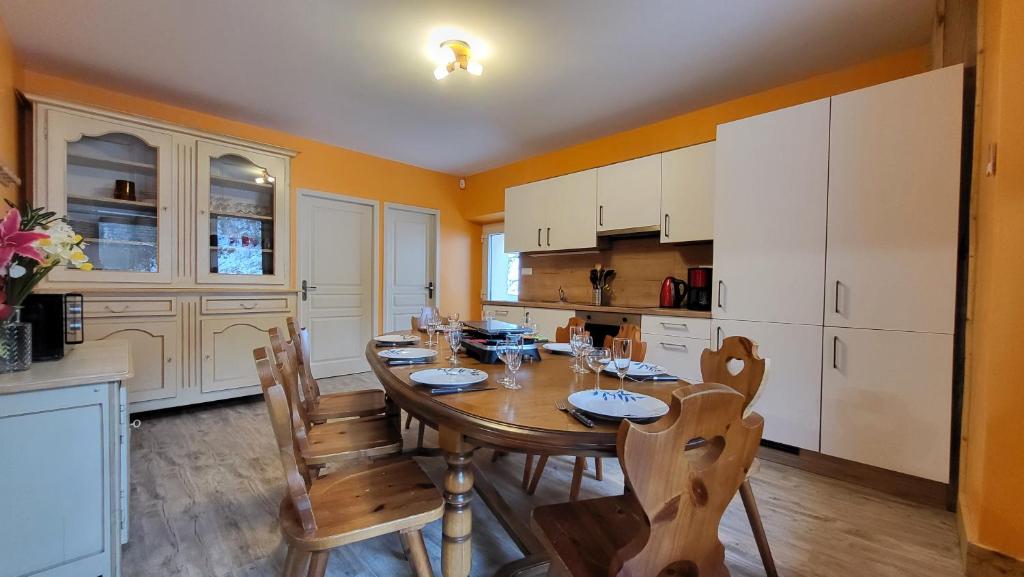 Il comprend une cuisine avec une table et des chaises en bois. dans l'établissement Le Bouquetin, à Entremont