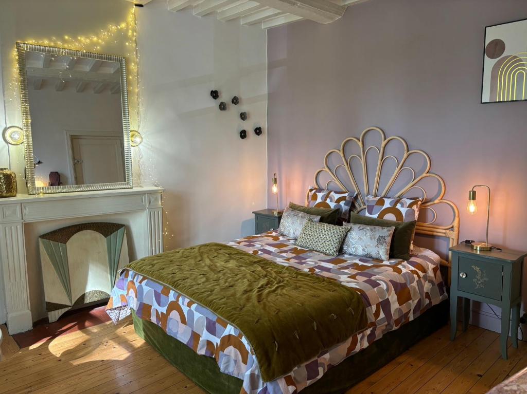sypialnia z dużym łóżkiem i lustrem w obiekcie B&B Nathalie w mieście Bayeux