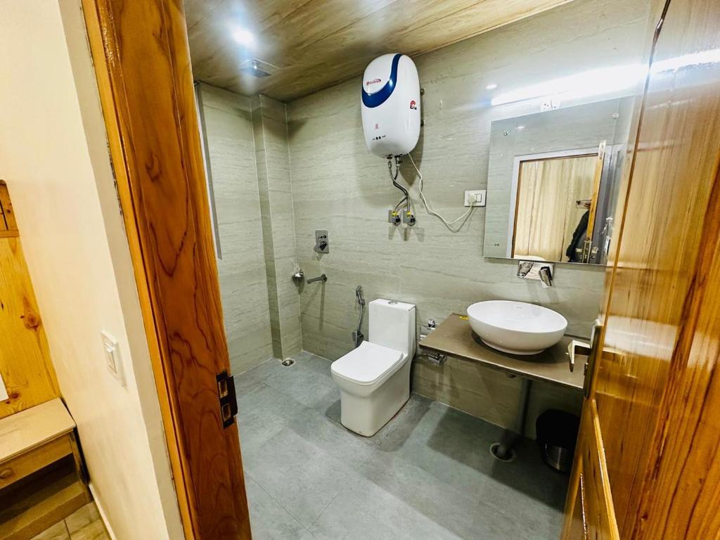 a bathroom with a toilet and a sink at The Exotic Retreat in Manāli