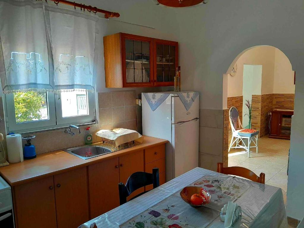 a kitchen with a table and a white refrigerator at Katerina's House in Sitia